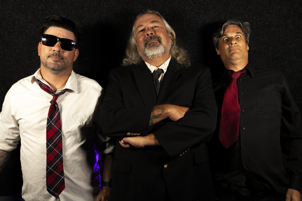 El Sancho band promo photo — Al, Tony, and Nate in ties and sunglasses against a black backdrop